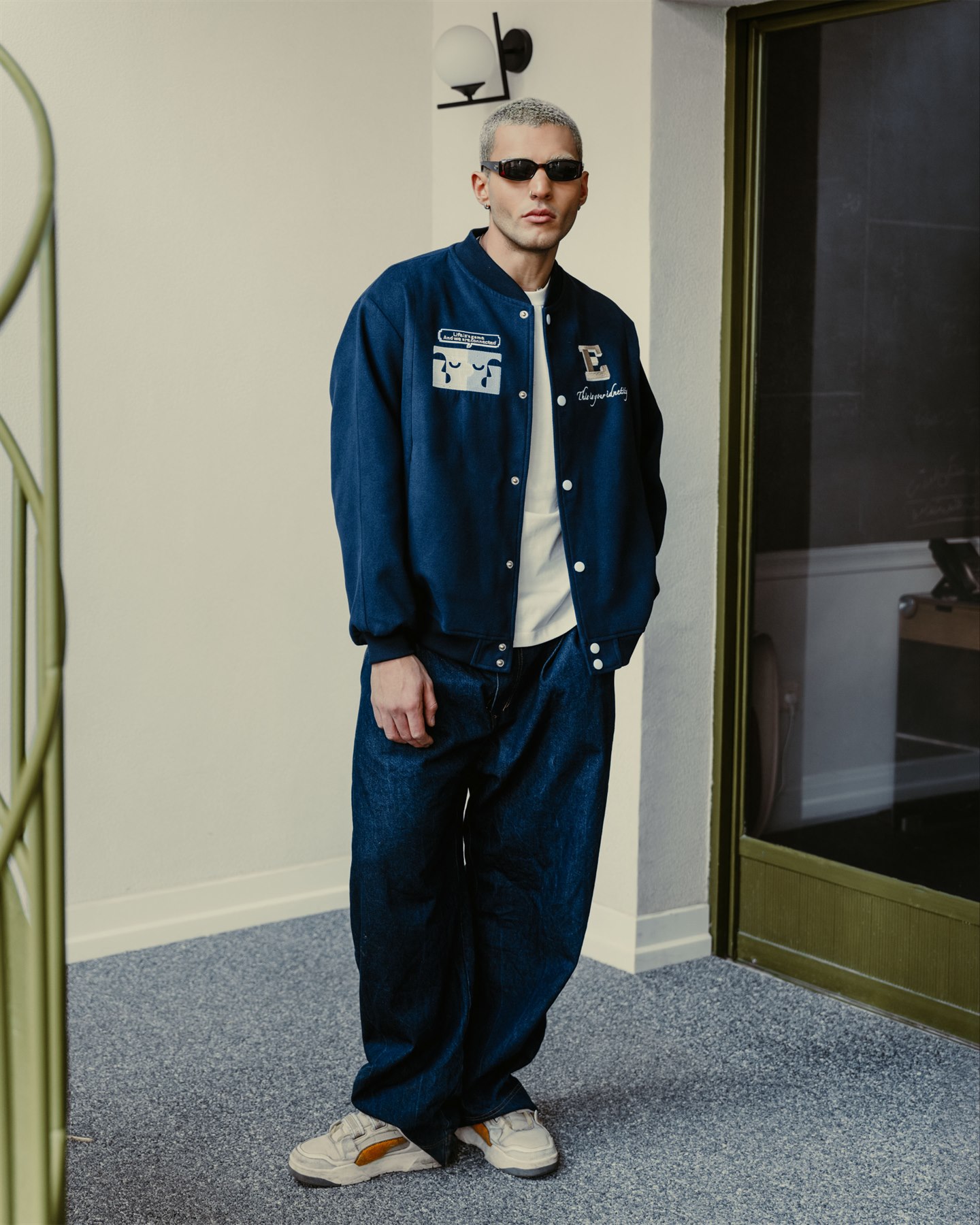 Model wearing a blue varsity jacket